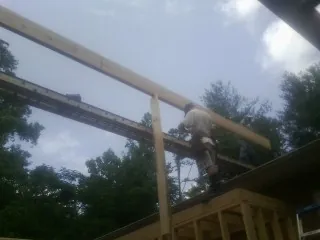 Carpenter setting a ridge beam over a new addition frame — Ice Dam Removal by Roofing Brothers in Moxahala