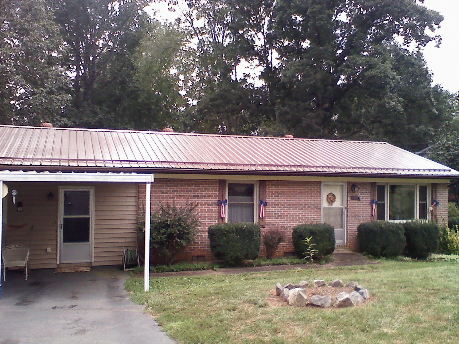 Bronze metal roof and carport on a brick ranch home — Roof Repair work by our crew in Moxahala