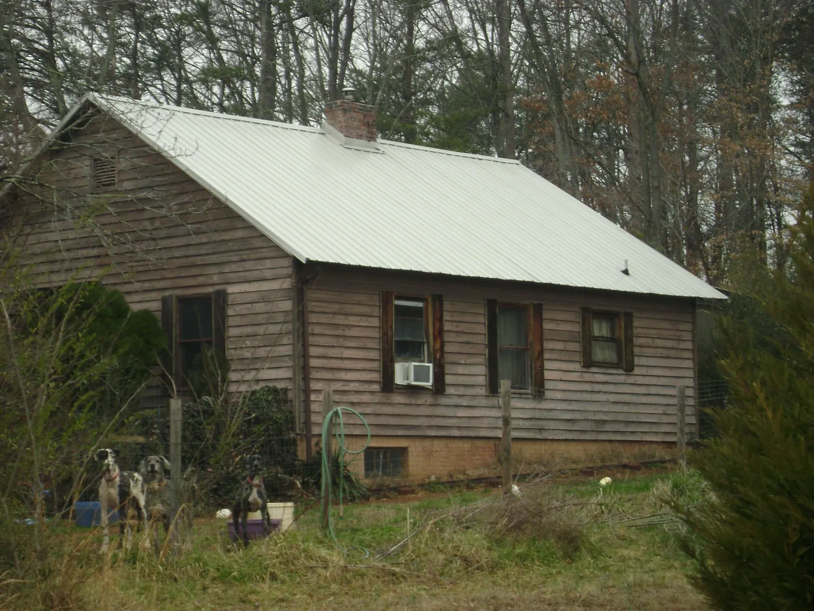 White metal roof on an old wood sided farmhouse, from a Metal Roof Installation job in Moxahala